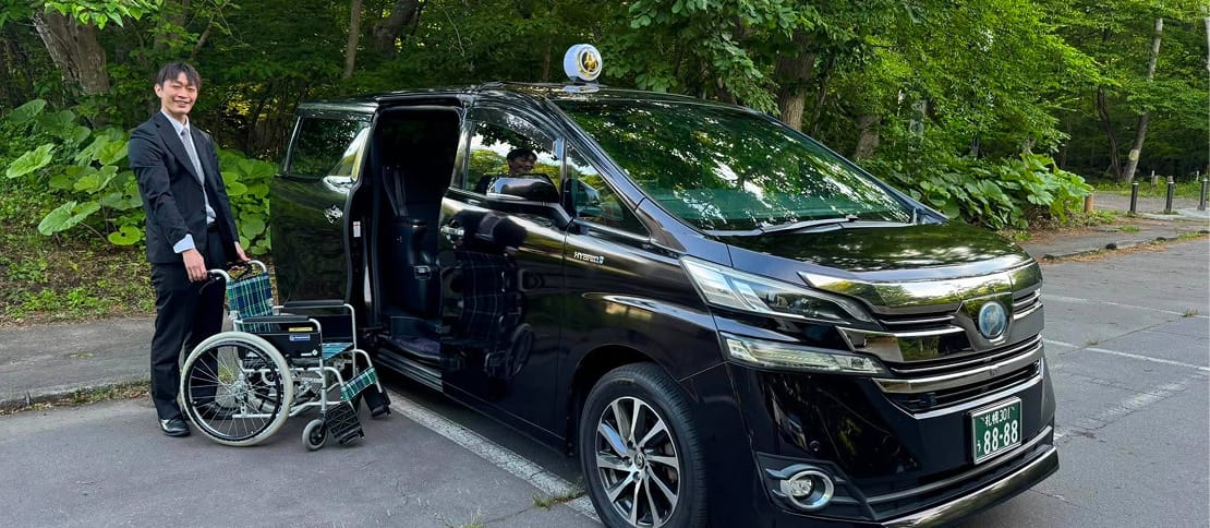 車椅子を準備する福祉タクシーのドライバーと専用車両